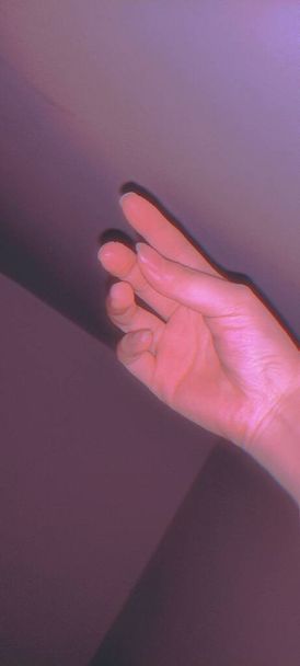 woman hand with pink manicure on a purple background - Fotoğraf, Görsel