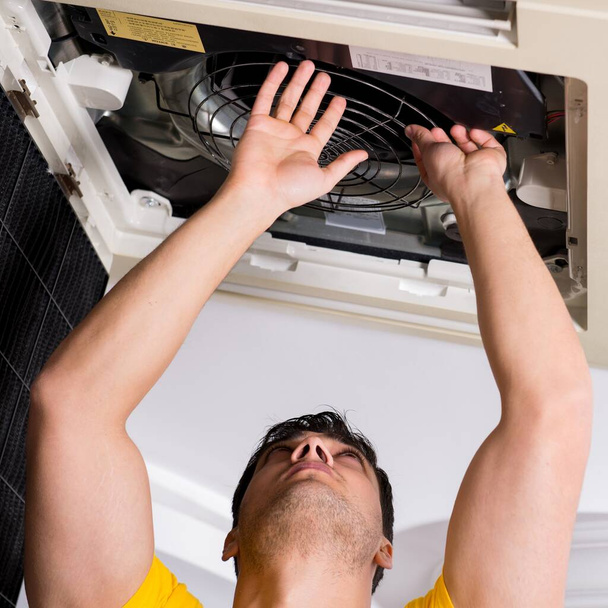 Reparateur repariert Klimaanlage an der Decke - Foto, Bild