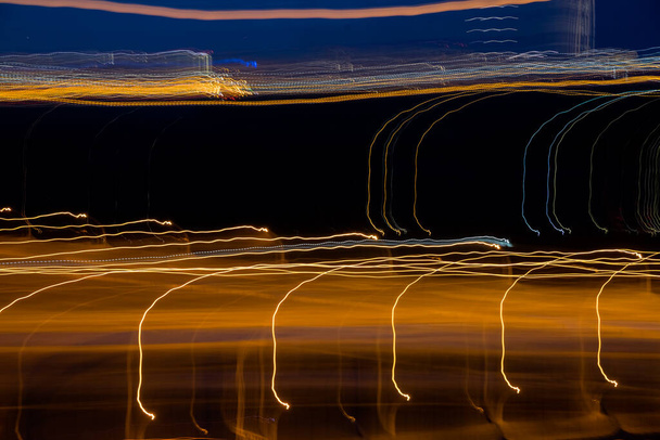 Sfondo astratto di luce notturna sulla strada, lunga esposizione shot.Abstract velocità di movimento.Fotografia a lunga esposizione di luci su sfondo nero.linee a strisce arancioni - Foto, immagini