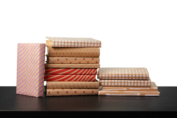 Stack of books on wooden table against white background - Foto, Imagen