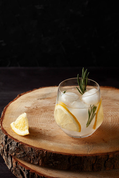 refreshing drink with lemon rosemary and ice on dark wooden background - Fotografie, Obrázek