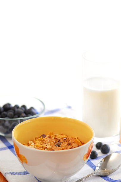 Healthy breakfast of cereal, milk and blueberries served on a table on sunny morning - Foto, Imagen