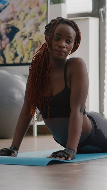 Mujer negra flexible practicando deporte durante el entrenamiento matutino de yoga - Foto, Imagen