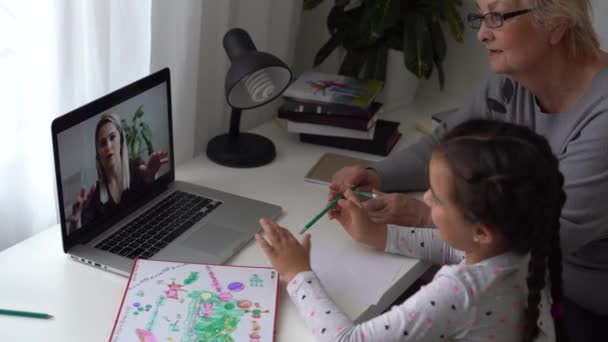 κοριτσάκι που σπουδάζει με τη γιαγιά της στο σπίτι, χρησιμοποιεί φορητό υπολογιστή για εκπαίδευση, online μελέτη, σπίτι που σπουδάζει. Το κορίτσι έχει διάβασμα στην εξ αποστάσεως εκπαίδευση. Lifestyle έννοια για οικογενειακή καραντίνα covid-19. - Πλάνα, βίντεο