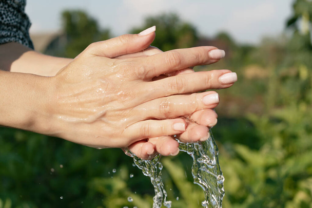 жіночі руки у воді на тлі природи
 - Фото, зображення
