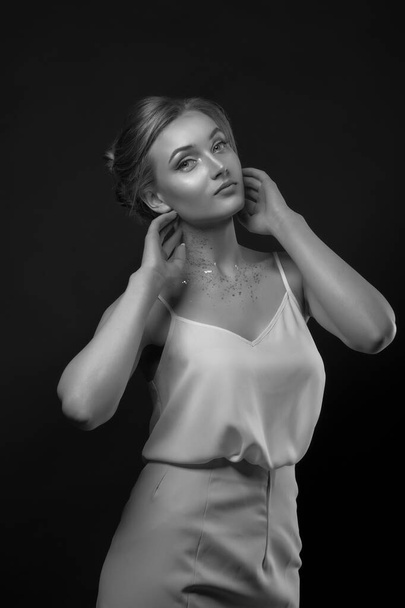 Mulher loira elegante usa vestido de seda branca posando na sombra no estúdio. Preto e branco tiro - Foto, Imagem
