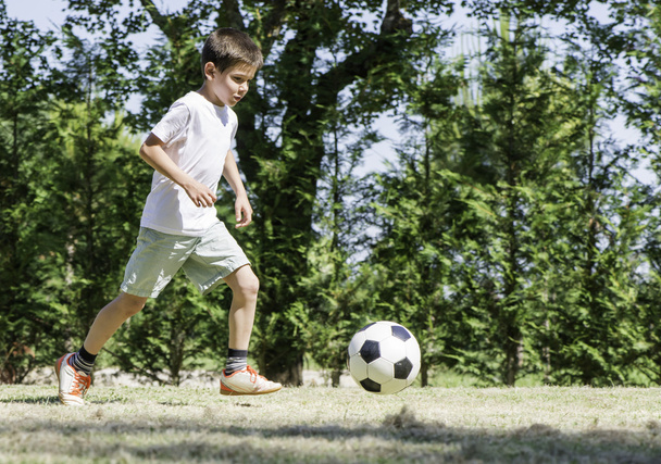 Child playing football in a stadium - Fotografie, Obrázek
