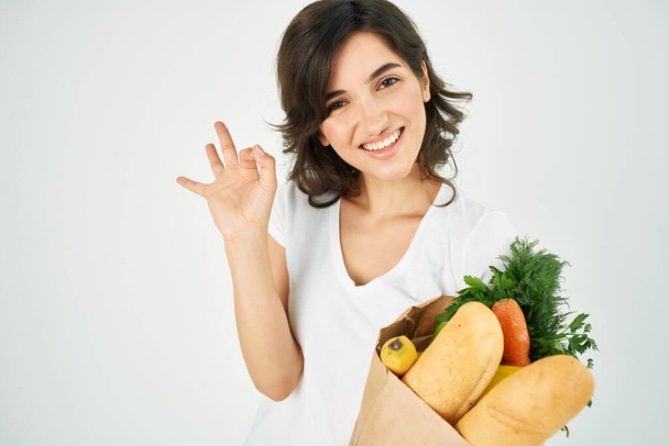милая брюнетка в белой футболке с овощами супермаркет - Фото, изображение