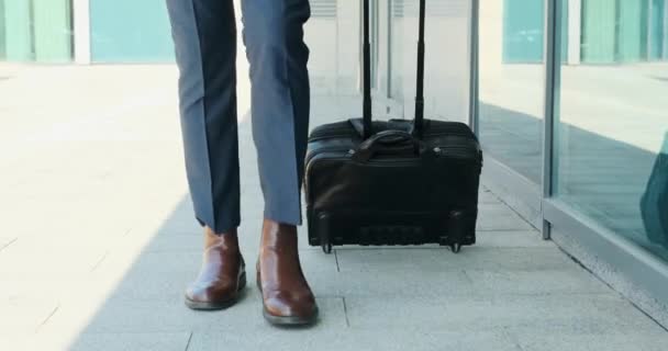 Businessman pulling luggage at airport - Materiał filmowy, wideo