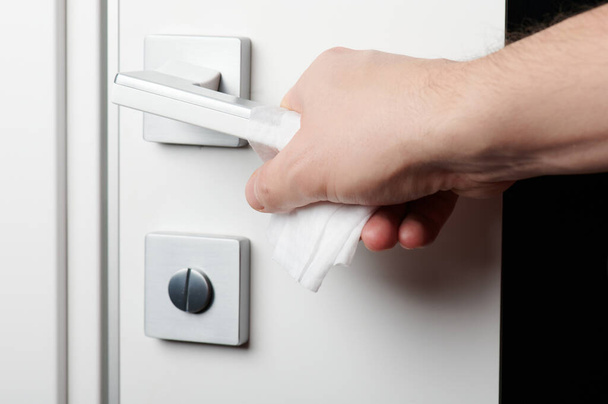 Open door handle with wet wipe on hand close up view - Фото, изображение