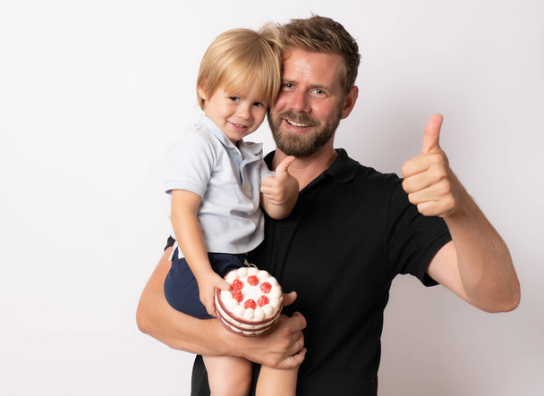 Feliz padre sosteniendo a su hijo con los pulgares hacia arriba gesto aislado en blanco - Foto, imagen