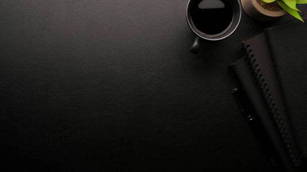 Elegante espacio de trabajo, todo negro, fondo negro, cuaderno negro, taza de café negro, espacio de copia para sus marcas, disposición plana - Foto, Imagen