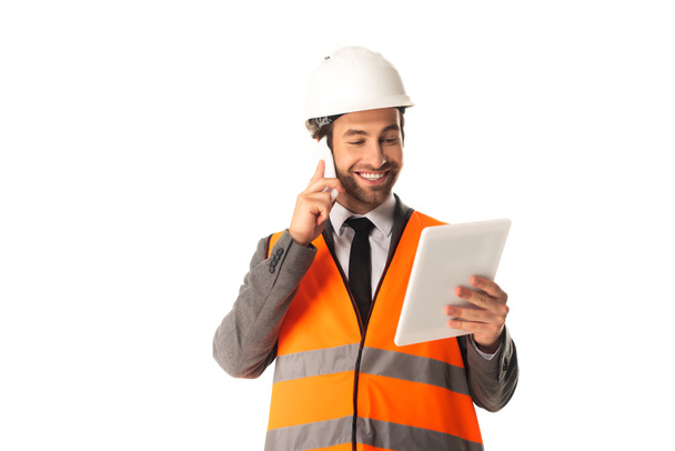 Engineer talking on cellphone and holding digital tablet isolated on white  - Foto, Bild