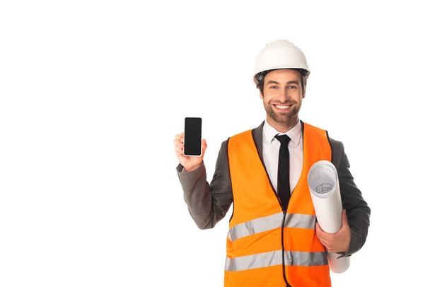 Smiling engineer holding smartphone and blueprint isolated on white  - Foto, Imagem