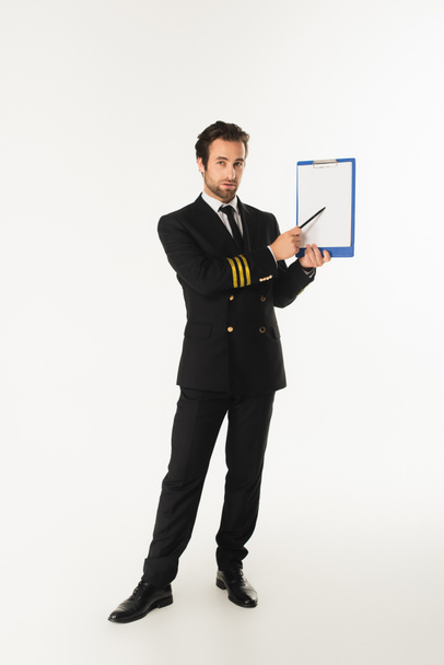 Aviador apuntando al portapapeles sobre fondo blanco  - Foto, imagen