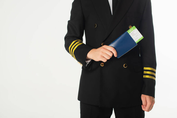Άποψη του αεροπόρου με κοστούμι που φέρει διαβατήριο και κάρτα επιβίβασης και είναι απομονωμένος σε λευκό χρώμα  - Φωτογραφία, εικόνα