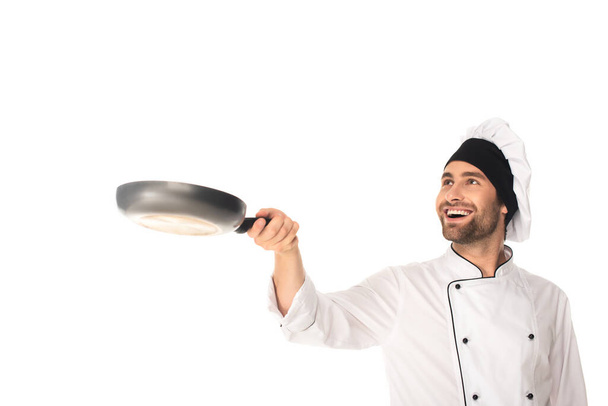 Smiling chef holding blurred frying pan isolated on white  - Fotografie, Obrázek