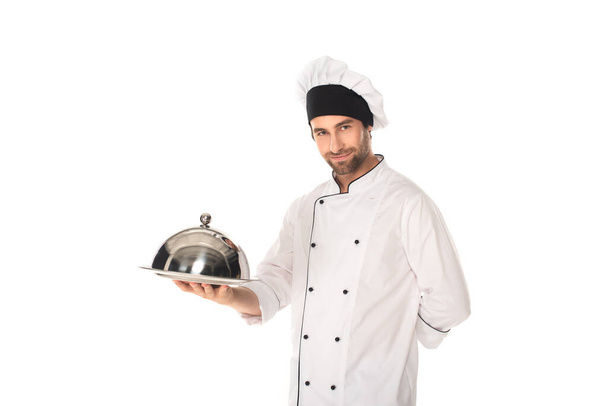 Chef en uniforme tenant cloche et plateau isolé sur blanc  - Photo, image