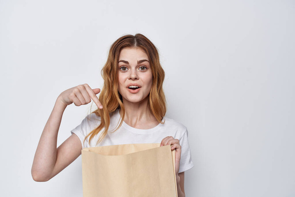 bonita mujer en camiseta blanca con bolsa de compras en la mano - Foto, imagen