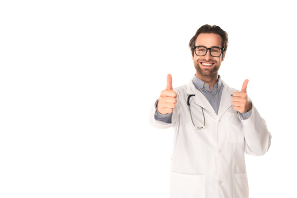 Smiling doctor showing thumbs up isolated on white  - Foto, imagen