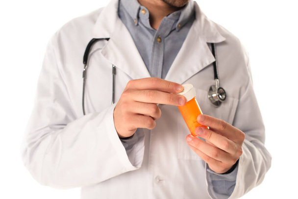 Cropped view of blurred doctor holding jar with pills isolated on white  - Фото, зображення