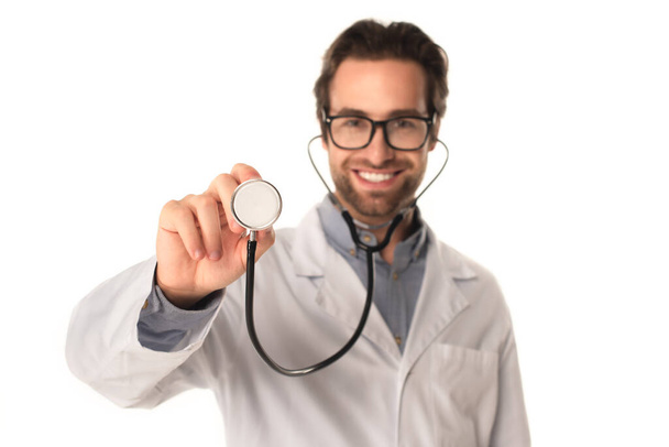 Размытый доктор держит стетоскоп изолированным на белом  - Фото, изображение