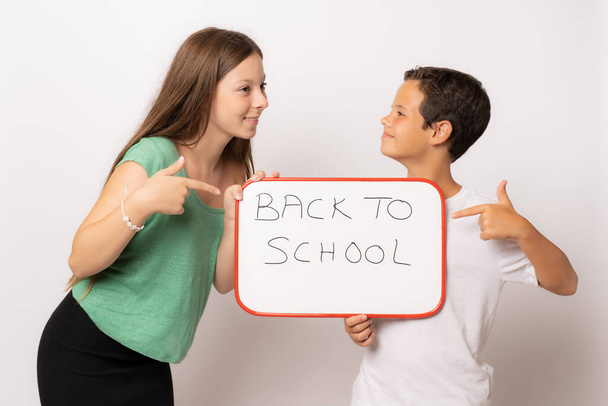 Dois estudantes sorridentes felizes mostrando tabuleta. Voltar ao conceito de escola. - Foto, Imagem