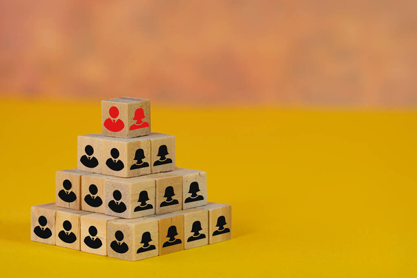 Концепция бизнес-кадров. Пирамида деревянных блоков с иконами мужчины и женщины. - Фото, изображение