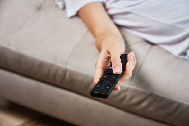 Woman switch channels on TV set with remote control. - Фото, зображення