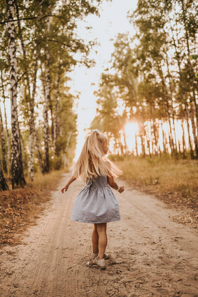 kislány táncol egy nyírfa sikátorban - Fotó, kép