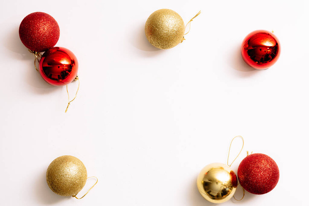 Weihnachtsbaumspielzeug isoliert auf weißem Hintergrund. Kopierraum. Neujahrsrahmen aus goldenen und rot glänzenden Kugeln. Feiertagsbanner. Modestil. Nahaufnahme. Visitenkarte. Grußurkunde-Attrappe. - Foto, Bild