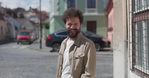 casual όμορφος άντρας αισθάνεται ενθουσιασμένος και χαμογελά πλατιά στην πόλη - Πλάνα, βίντεο