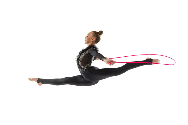 One Caucasian girl, rhythmic gymnastics artist isolated on white studio background. Concept of sport, action, aspiration, education, active lifestyle - 写真・画像