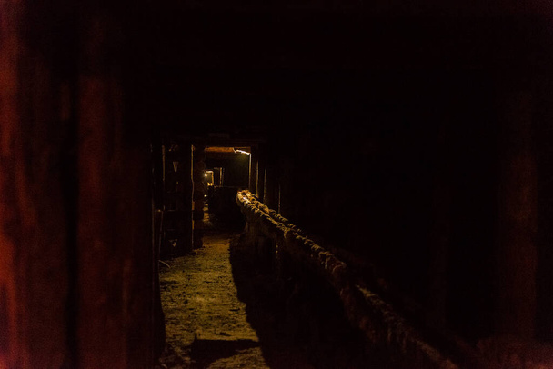 Antiguo corredor apuntalado con vigas de madera como fondo en la mina de sal de Wieliczka, Cracovia, Polonia  - Foto, Imagen