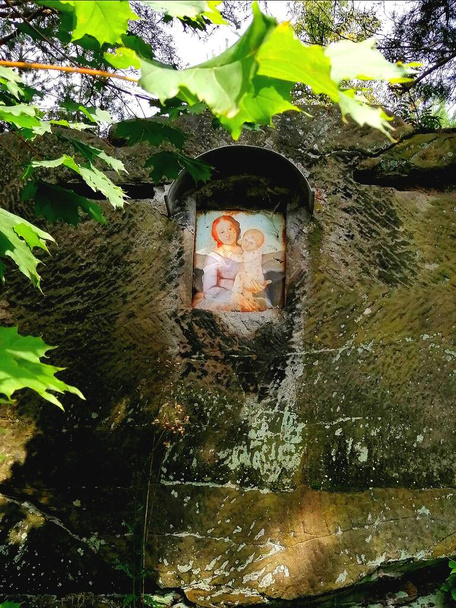 聖母マリアと自然祭壇。自然の岩の中に置かれた赤ちゃんイエスと聖母マリアの絵.  - 写真・画像