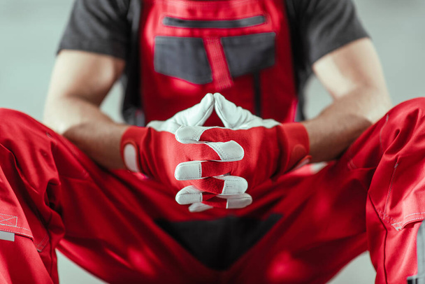Professional Contractor Worker in a Red Uniform and Safety Gloves Awaiting Next Tough Job Concept Photo. - Photo, Image
