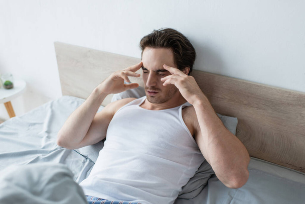 Mann berührt Kopf bei Migräne am Morgen - Foto, Bild