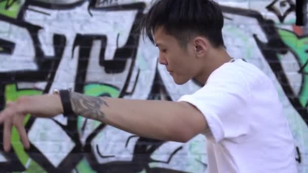 若いアジアの男が屋外でヒップホップを踊る。ストリートモダンダンサー、若者のライフスタイル - 映像、動画