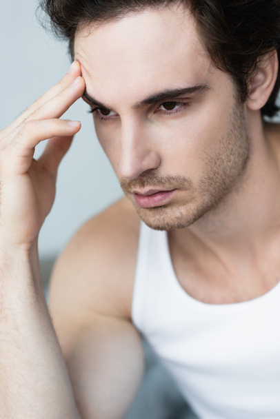 молодий депресивний чоловік торкається чола вранці
 - Фото, зображення