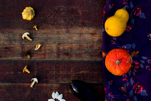 Cornice autunno Composizione e disposizione fatta di zucche colorate, melanzane, fiori viola tessile, funghi invecchiato vintage vecchio sfondo rosso Focus selettivo. - Foto, immagini