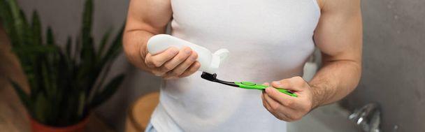 partial view of man applying toothpaste on toothbrush, banner - Фото, изображение