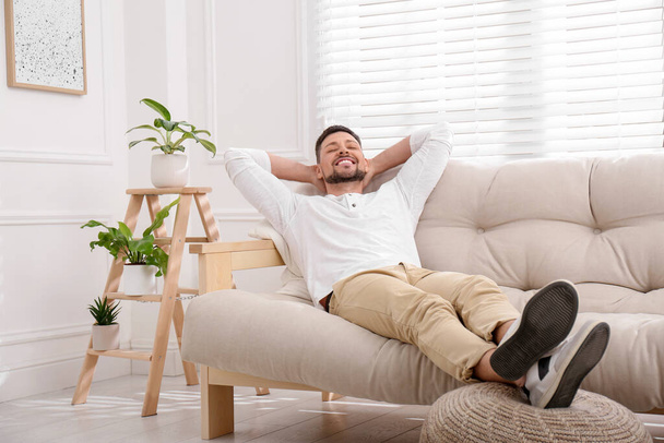 Handsome man relaxing on sofa at home - Photo, Image