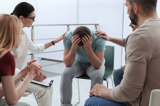 Psychotherapist working with group of drug addicted people at therapy session indoors - Foto, afbeelding