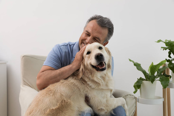 Glücklicher Senior mit Golden Retriever-Hund zu Hause - Foto, Bild