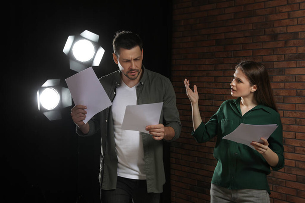 Professional actors reading their scripts during rehearsal in theatre - Photo, image