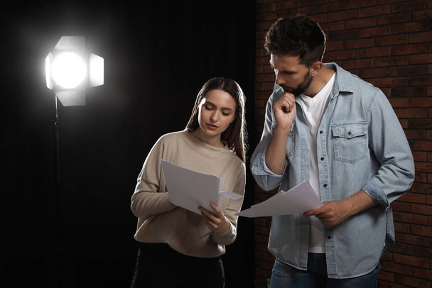 Professional actors reading their scripts during rehearsal in theatre - Photo, Image