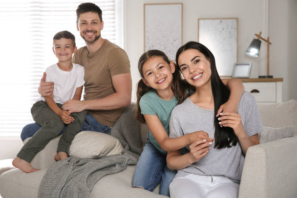 Portrait of happy family in living room. Adoption concept - 写真・画像