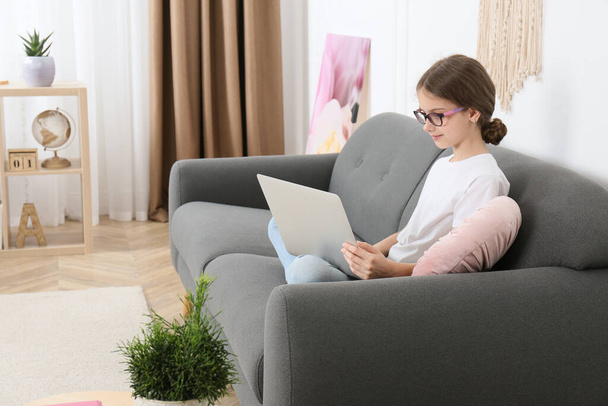 Girl with laptop on sofa at home - Fotoğraf, Görsel