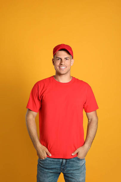 Happy man in red cap and tshirt on yellow background. Mockup for design - Fotografie, Obrázek