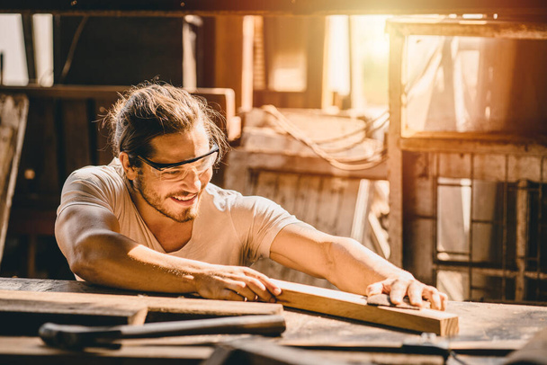 Trabajador masculino feliz trabajando. Carpintero hombre profesional de alta habilidad personas en el trabajo para la obra maestra de madera en el taller de muebles. - Foto, imagen